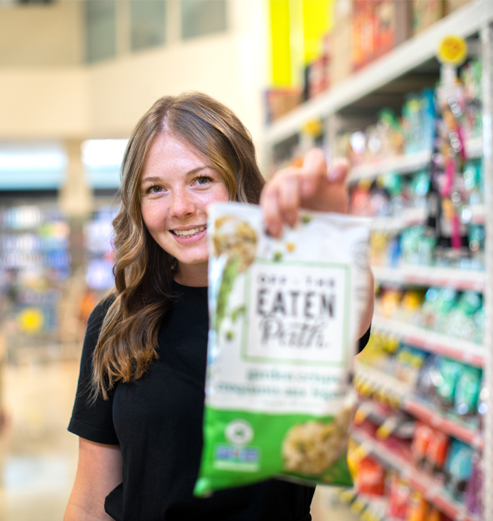 Woman holding a bag of Off The Eaten Path