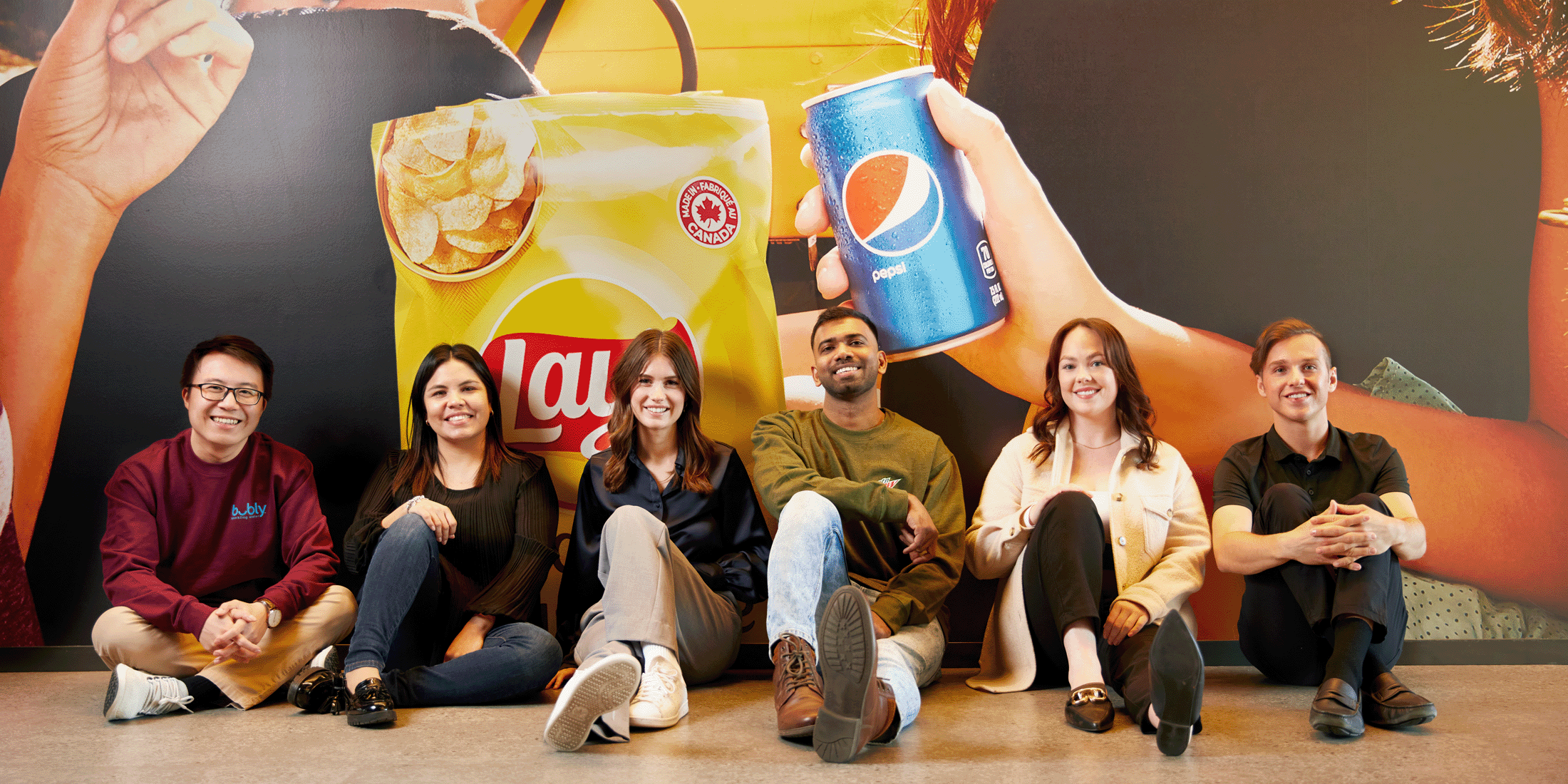 Employees sitting together against a wall