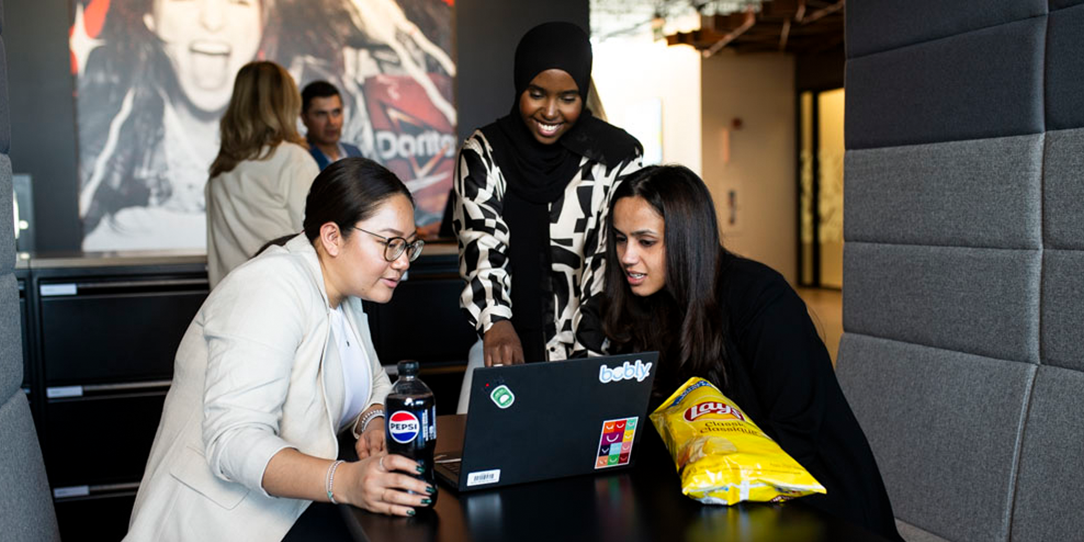 Employees looking over work on a laptop together